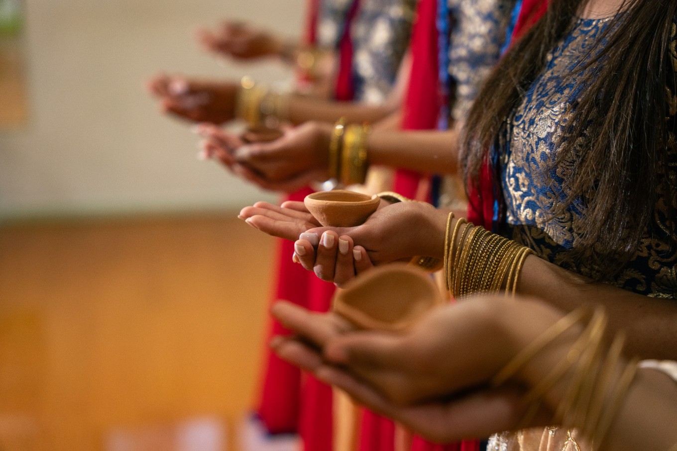 People holding clay cups.
