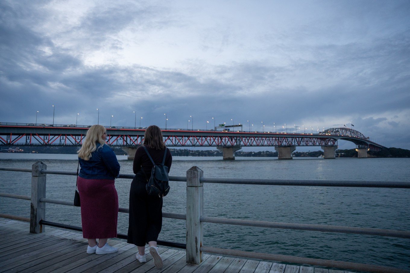 Two women watching the harbour bridge. 